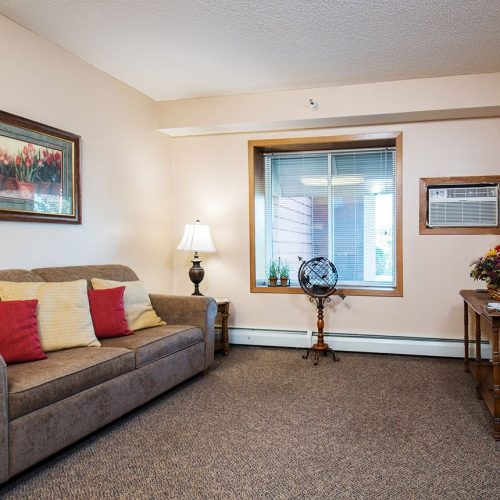 Comfortable living room with seating, warm lighting, and thoughtful decor for a welcoming community space.