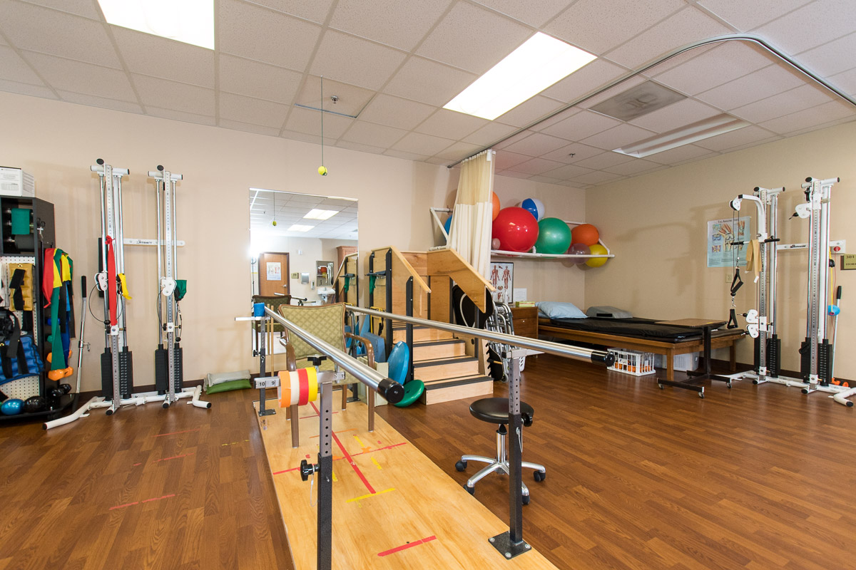 Bright rehabilitation room with exercise equipment and supportive therapy tools for active recovery.