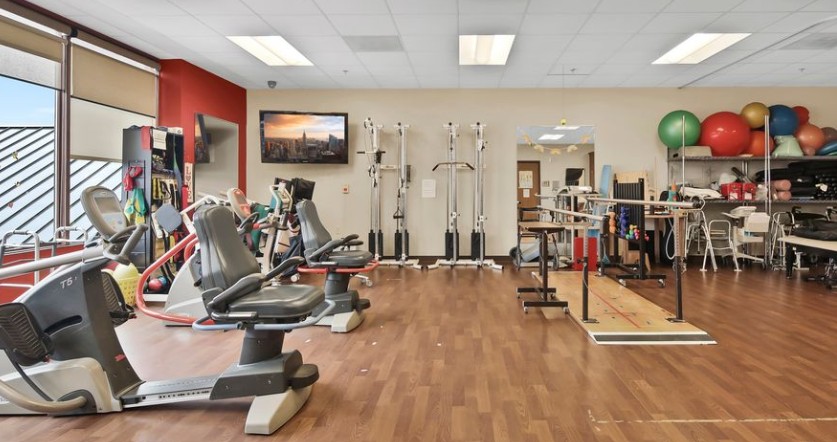 Bright and accessible rehab gym with modern equipment and inviting community atmosphere.