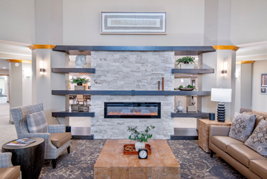 Welcoming lounge with modern fireplace, comfortable seating, and warm, inviting decor.