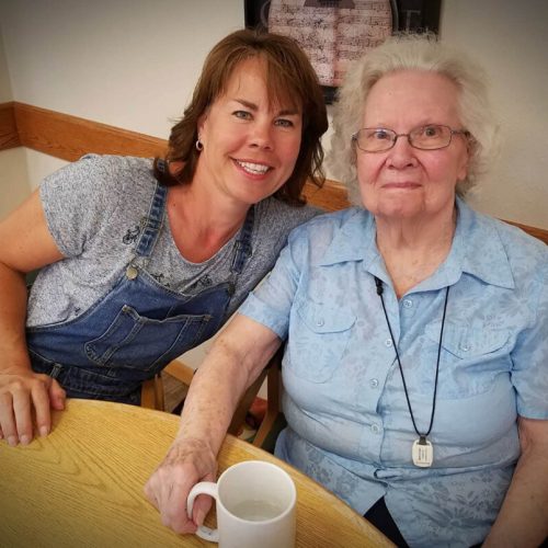 Two women sharing a warm moment together in a bright, welcoming dining area.