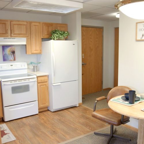 Bright kitchen and dining area with wooden cabinets and comfortable seating for shared meals.