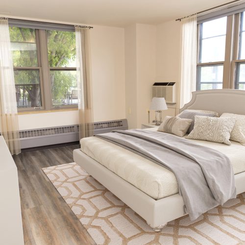 Sunlit bedroom with soft linens, patterned rug, and gentle decor for a restful stay.