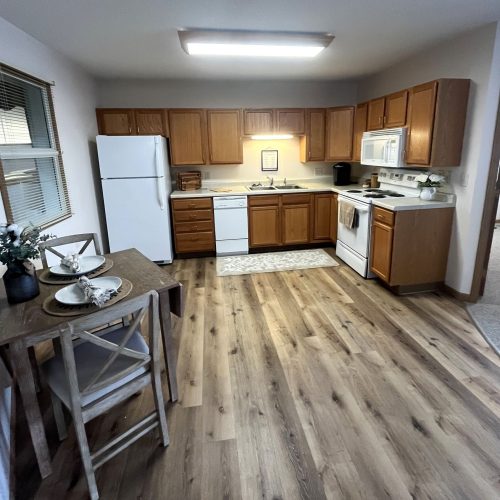 Spacious kitchen and dining area with warm wood tones and natural light, inviting shared meals.