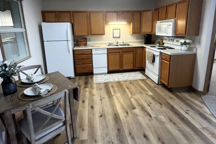 Spacious kitchen and dining area with warm wood tones and natural light, inviting shared meals.