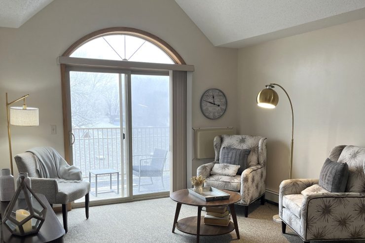 Bright common room with comfortable seating, soft lighting, and a view to a quiet balcony.