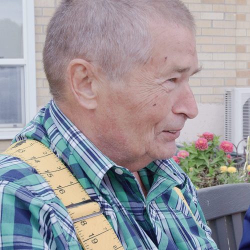 Senior man sitting outside with associate