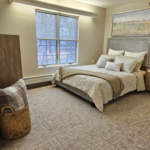 Well-lit bedroom with inviting bedding and peaceful views, designed for comfort and relaxation.