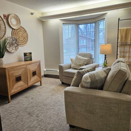 Sunlit living space with comfortable seating, soft lighting, and warm decorative accents.