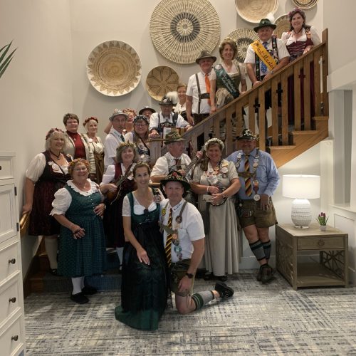 A lively group in traditional attire gathers on a staircase, celebrating community and culture.