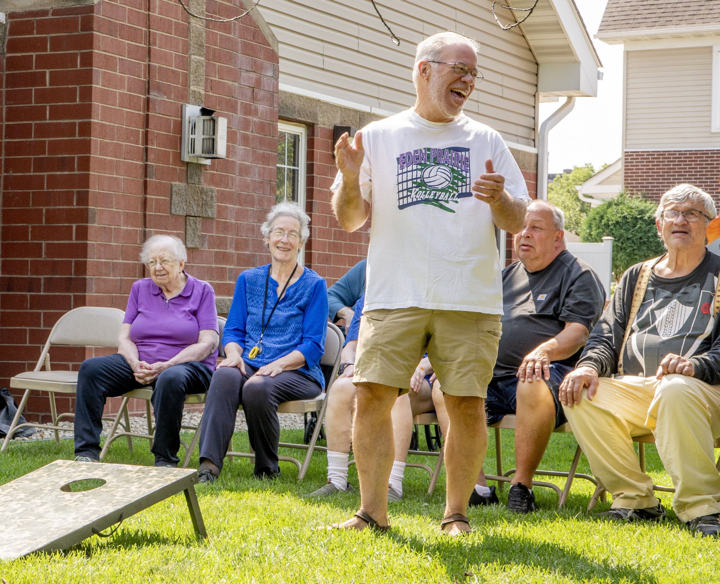 Seniors enjoy a lively outdoor game and friendly conversation on a sunny day.