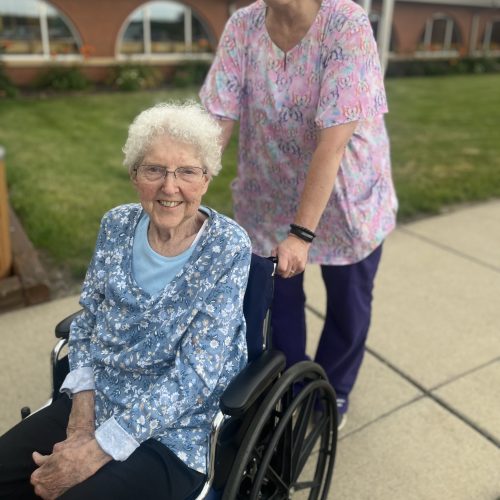 Associate pushing senior female in wheelchair