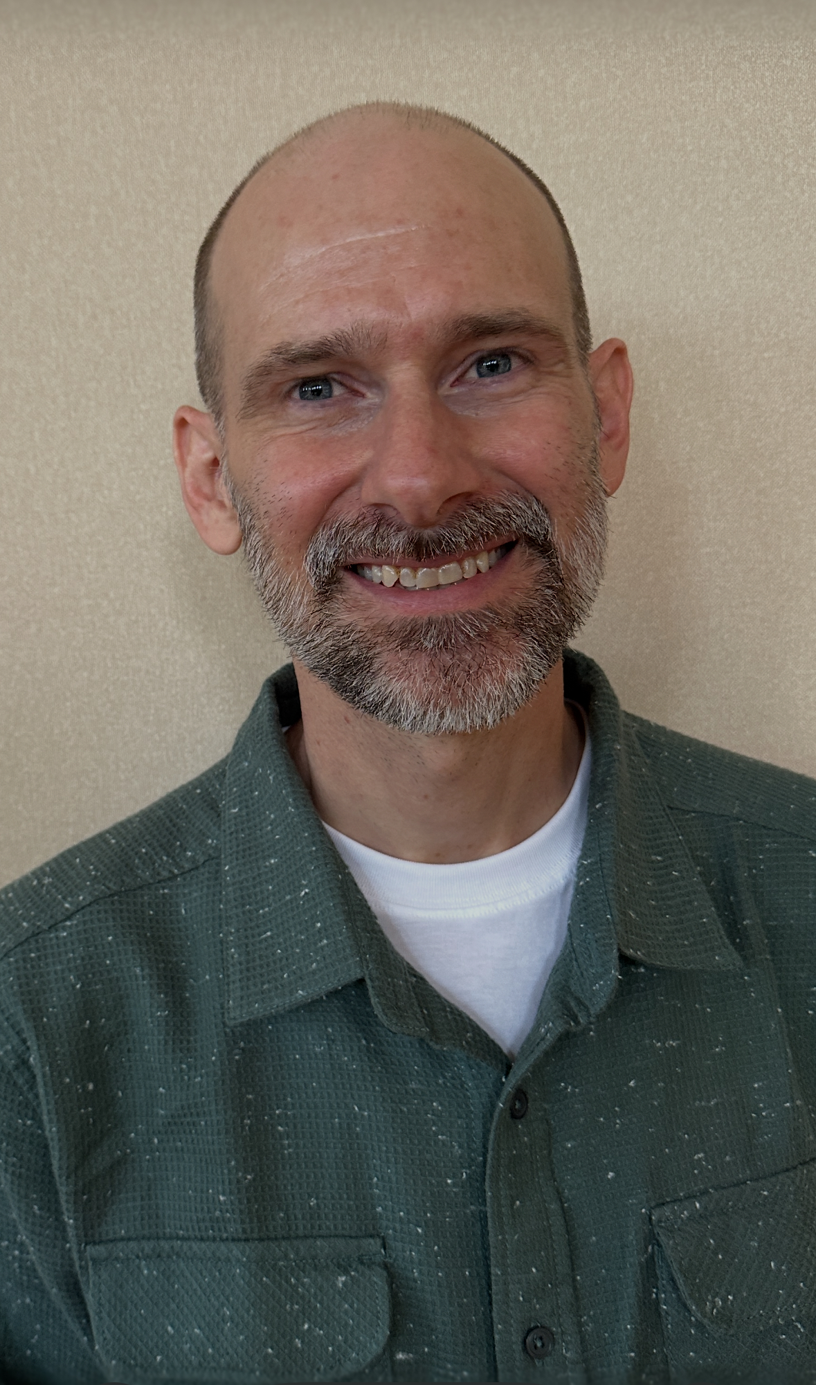 Friendly man with a warm smile in a relaxed, welcoming environment.