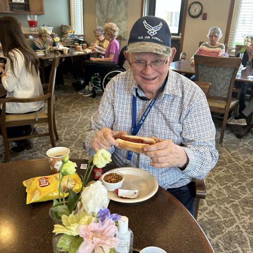 Residents enjoying a shared meal in a bright, welcoming dining room with friendly conversation.