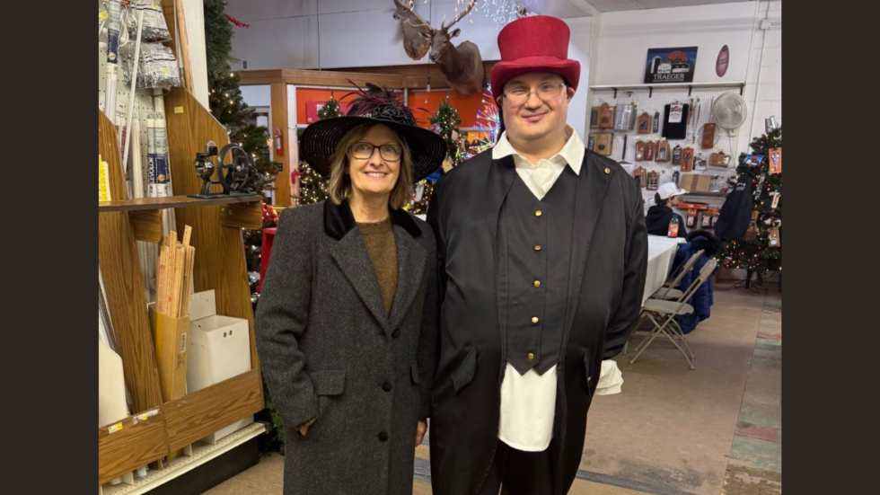 Two residents dressed in festive holiday attire enjoy a warm community gathering.